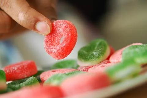 Selecting a candy on a table with others nearby Stock Photos