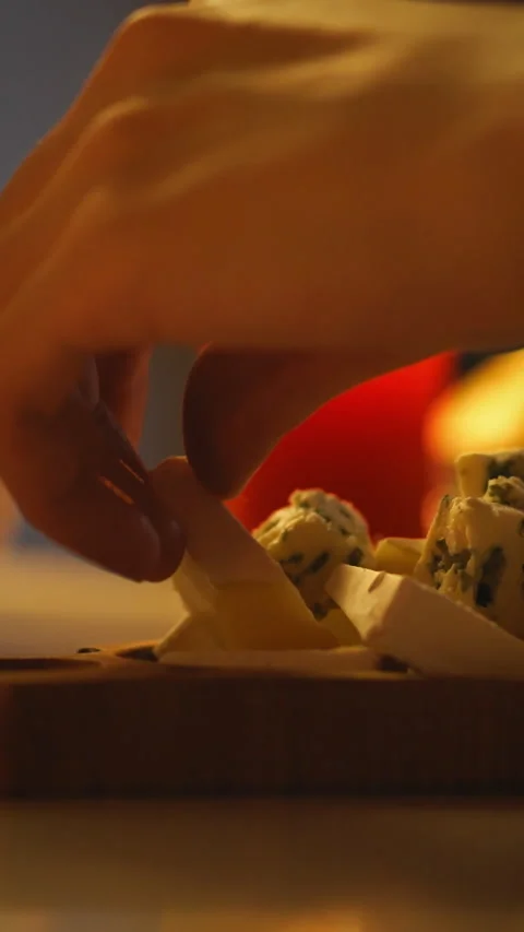 Selecting cheese from a wooden platter during an upscale dining experience Stock Footage 331726073