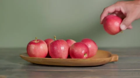 Selecting a Fresh Apple From a Plate Vídeos de archivo 345097276