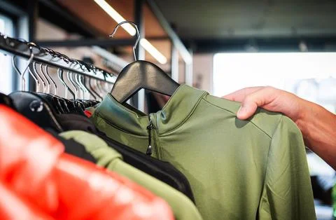 Selecting a Green Athletic Top in a Modern Clothing Store 写真素材