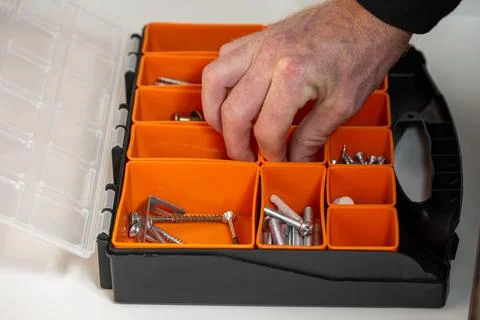 Selecting screws from organized toolbox during home repair Stock Photos