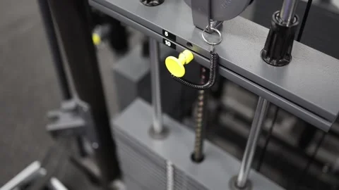 Selecting weight on cable machine Stock Footage 328995870