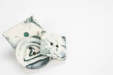 Selection of artisan handmade ceramic buttons isolated on a white background. Stock Photos