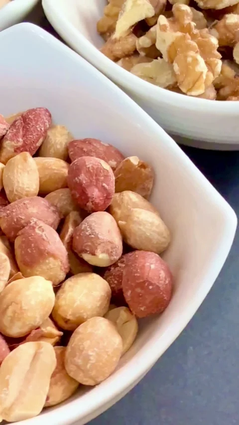 Selection of different nuts in white bowls on table Video stock 331980851