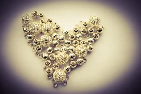 Selection of different silver beads shaped into a heart 스톡 사진