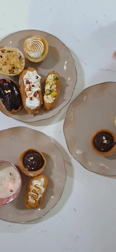 Selection of Eclairs Arranged on Plates, Viewed from Above. 库存影片 334893634