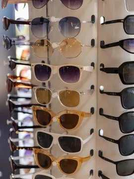 A selection of fashionable sunglasses is arranged on a display rack. The dive 스톡 사진