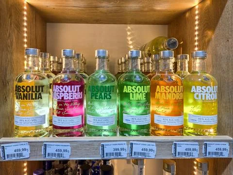 Selection of flavored Absolut vodka bottles arranged neatly on store shelf Stock Photos