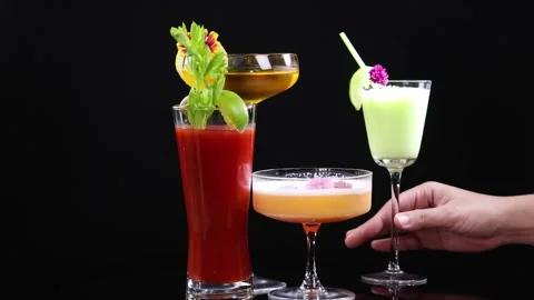 Selection of four colorful cocktails rotating on black background with huma.. Stock Footage 333696151