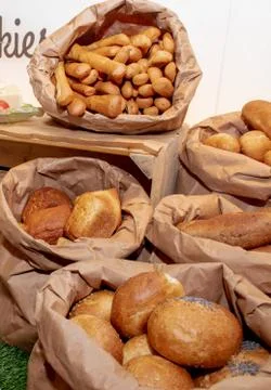 Selection of Fresh baked bread baskets and paper bags with bread roasted in t Stock Photos