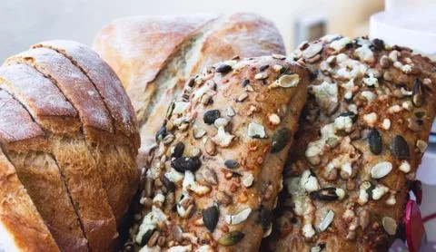 A selection of freshly baked bread rolls and buns covered with mixed seeds Stock Photos