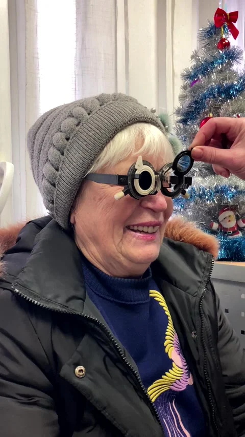 Selection of lenses for glasses. checking the vision of an old woman Stock Footage 298257728