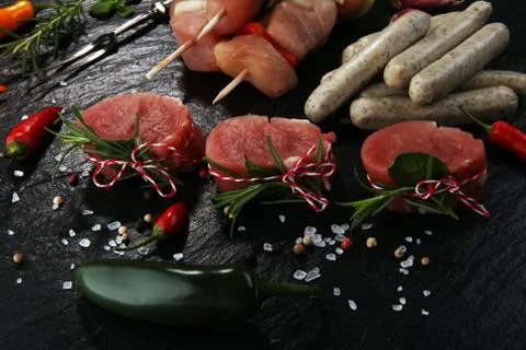 Selection of marinaded meat for bbq grilling with herbs on table Stock Photos