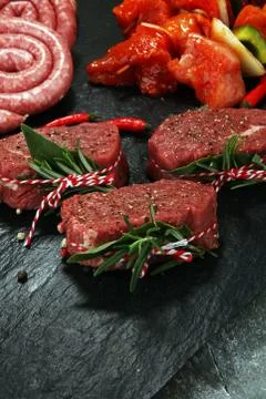 Selection of marinaded meat for bbq grilling with herbs on table Stock Photos