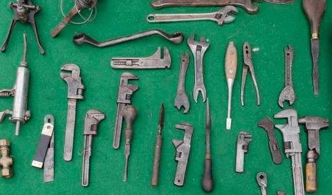 Selection of old handtools spanners adjustable wrenches on a green background Stock Photos