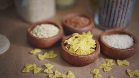 Selection of pasta, rice and grains in wooden bowls on rustic table. Natural Stock Footage 303639647