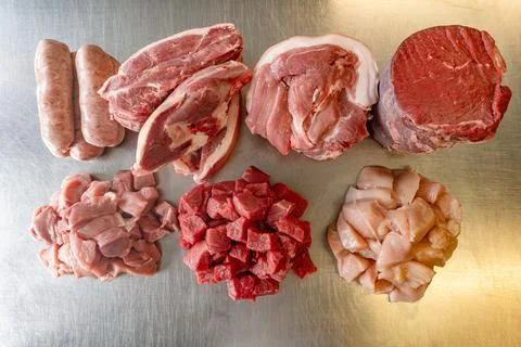 Selection of raw meat on a metal table: sausage, diced pork, lamb shoulder .. Stock Photos