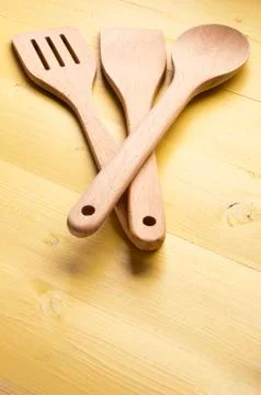 A selection of wooden kitchen utensils on yellow work surface Stock Photos