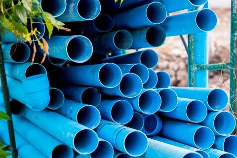 Selective to blue plastic pipe background. PVC pipes stacked in warehouse of  Stockfoto's