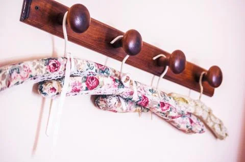 Selective closeup shot flower patterned clothes hangers on a brown wooden rod Stock Photos