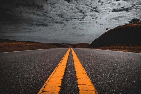 Selective color of perspective view of yellow lane lines from an old asphalt Stock Photos