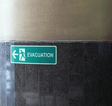 Selective fire exit sign on white ceiling. Stock Photos