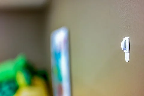 Selective focus on adhesive strip wall hanger that can be removed by pulling Stock Photos