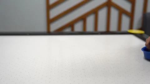Selective focus on the air hockey table. A child is playing air hockey with an Stock Footage 282812645