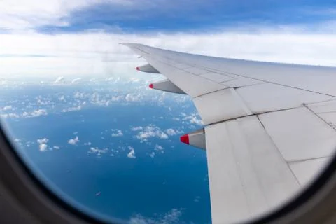 Selective focus Airplane wing view out of the window cloudy sky background Fotos de archivo