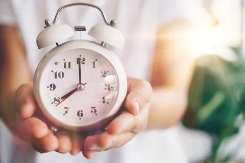 Selective focus of alarm clock with nature bokeh background. lifestyle prod.. Stock Photos