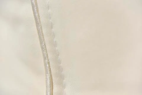 Selective focus at the atlas boarder near the white stitch on the beige fabri Foto stock