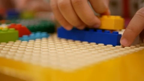 Selective focus of baby's hands playing interlocking bricks / blocks Video stock 103492185