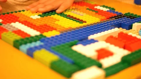 Selective focus of baby's hands rubbing on interlocking bricks / blocks Video stock 103492194