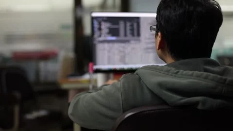 Selective focus to the back of the programmer is sitting to develop the program  Stock Footage 143966174