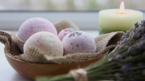 Selective focus on bath bombs and candle burning on background. 스톡 동영상 150214547