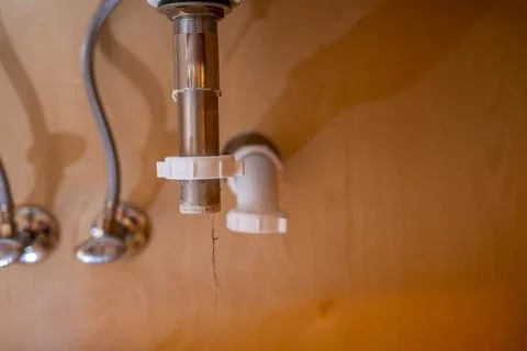 Selective focus on a bathroom sink drain disconnected with a hair clog hanging Stock Photos