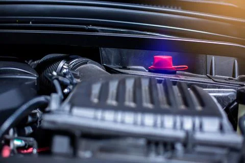 Selective focus to battery anode in the car engine room. Red plus pole batter Stock Photos