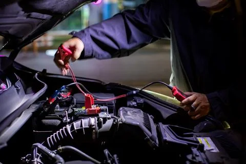 Selective focus to battery positive terminal and Mechanic or driver using j.. Stock Photos
