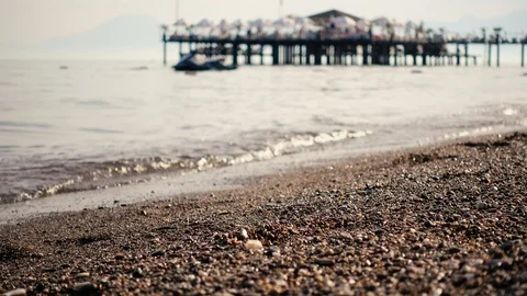 Selective focus. Beach with large sand and waves that run ashore in the defoc Vidéo 120107191
