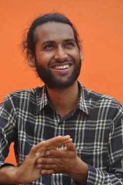 Selective focus of a bearded young man smiling while looking sideways Stock Photos