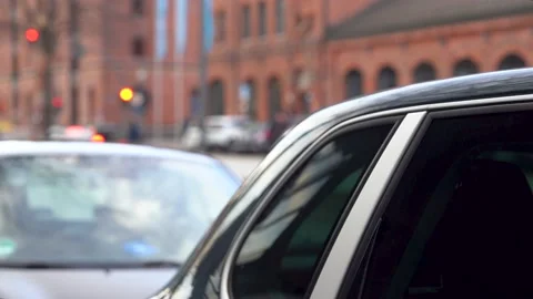 Selective focus behind a parked car, with view of flowing city traffic. Stock Footage 229211060