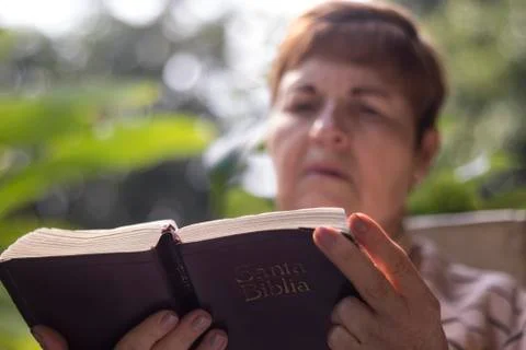 Selective focus on a Bible carried by an older woman Stock Photos