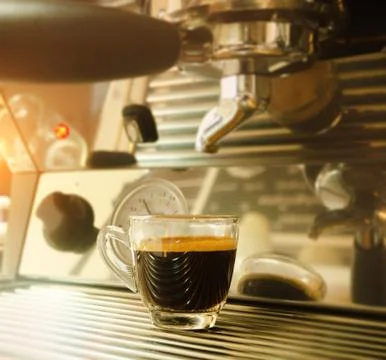 In selective focus of black coffee cup put on coffee machine,warm light tone, Stock Photos