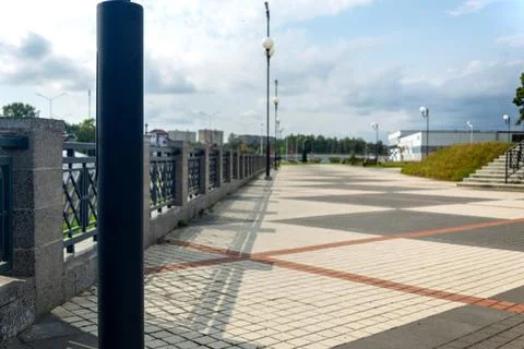 Selective focus on black metal lantern post with blurred view of paved city Stock Photos