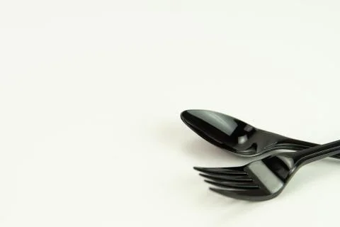 Selective focus of black shine spoon and fork with white background. Stock Photos