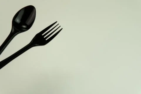 Selective focus of black shine spoon and fork with white background. Stock Photos