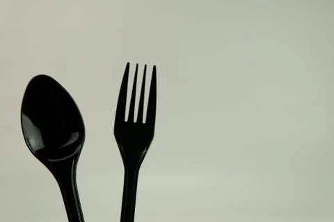 Selective focus of black shine spoon and fork with white background. Stock Photos
