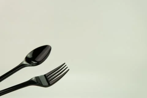 Selective focus of black shine spoon and fork with white background. Stock Photos