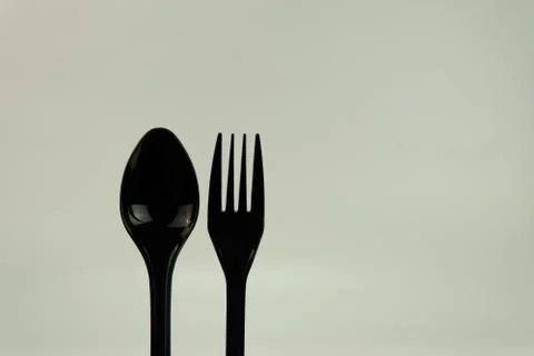 Selective focus of black shine spoon and fork with white background. Stock Photos