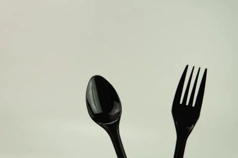 Selective focus of black shine spoon and fork with white background. Stock Photos